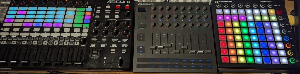 Three MIDI control surfaces side by side: two colour-lit grid pads and a mixer with faders and knobs